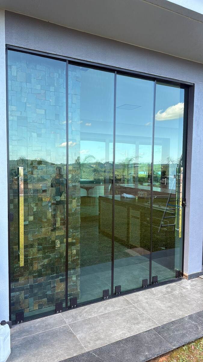 Porta de vidro temperado fumê — vista para o vale